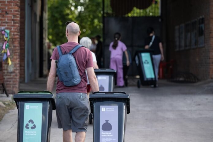 Vecinos trasladan contenedores intradomiciliarios de la Intendencia de Montevideo para residuos mezclados y reciclables